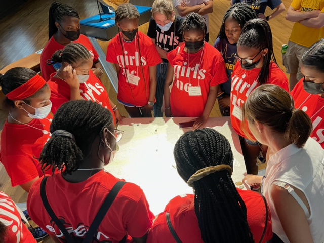 EUREKA! campers stand in a circle around a map