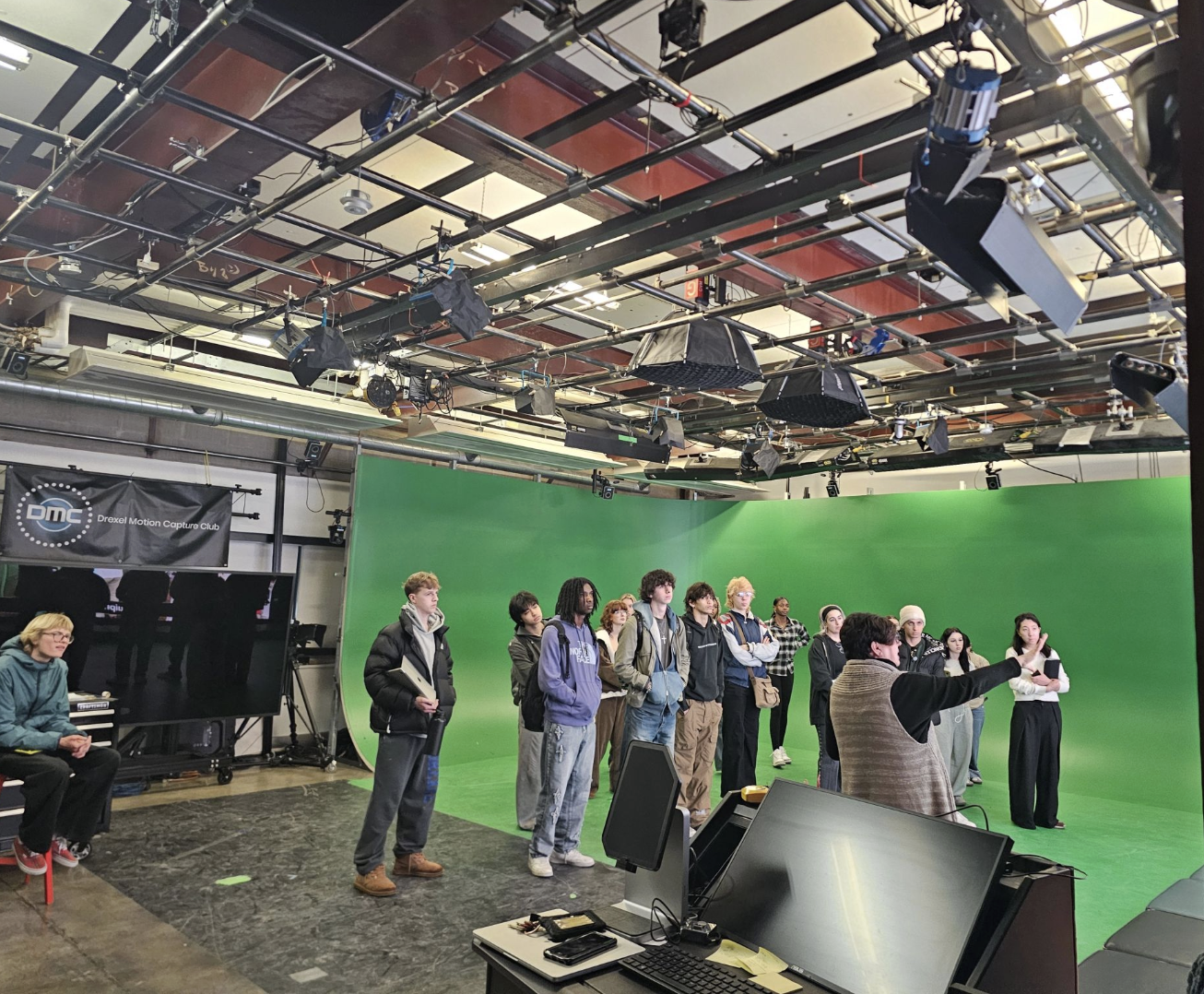 students gather in around green screen in immersive motion capture lab