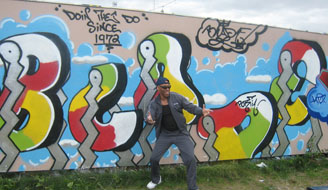 Graffiti artist Blade in front of a new graffiti piece of his name