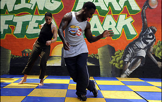 Evans teaches female dancer on blue and yellow checkered floor