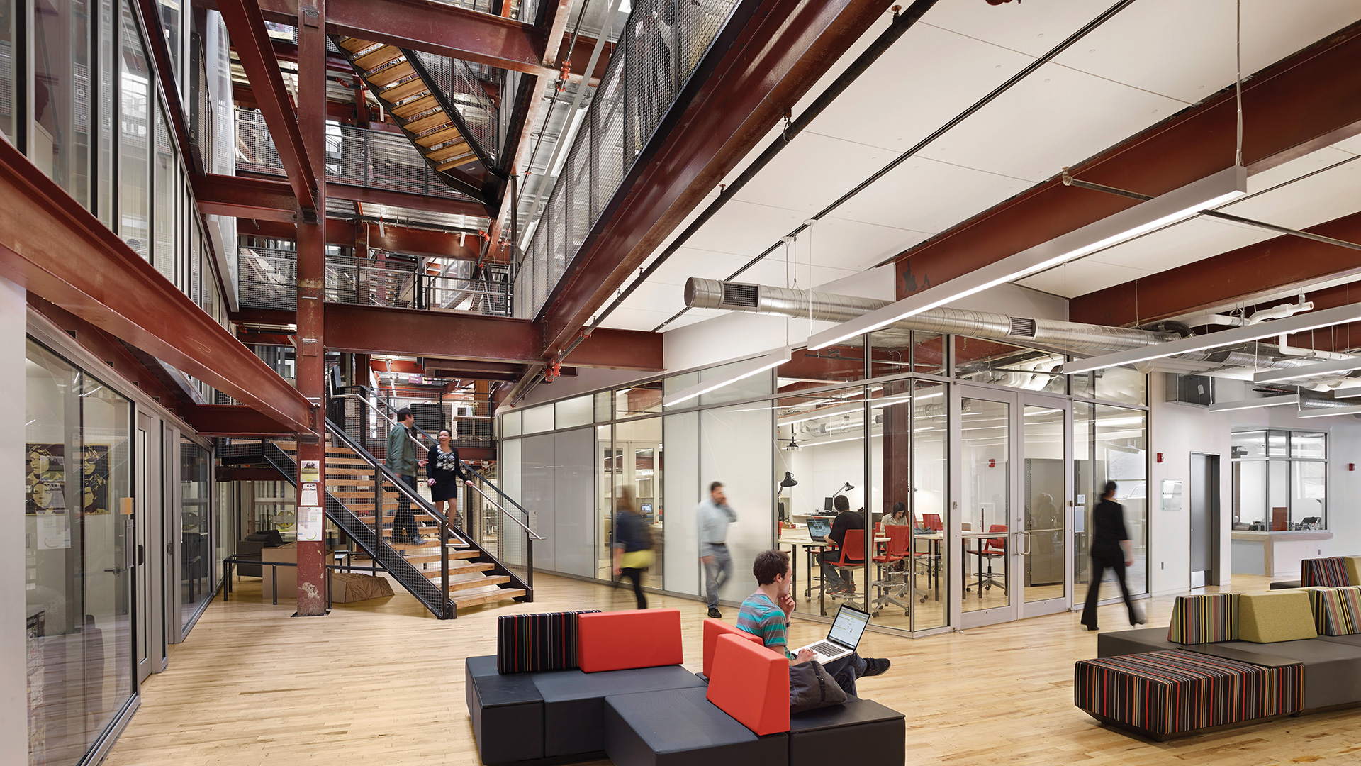 Photo of a student viewing their laptop from a couch in the URBN Center lobby.