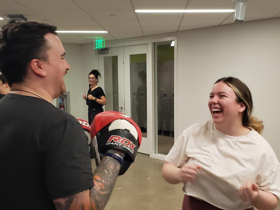 Two individuals smiling and having fun during a Self-Awareness for Everyone (SAFE) class on campus.
