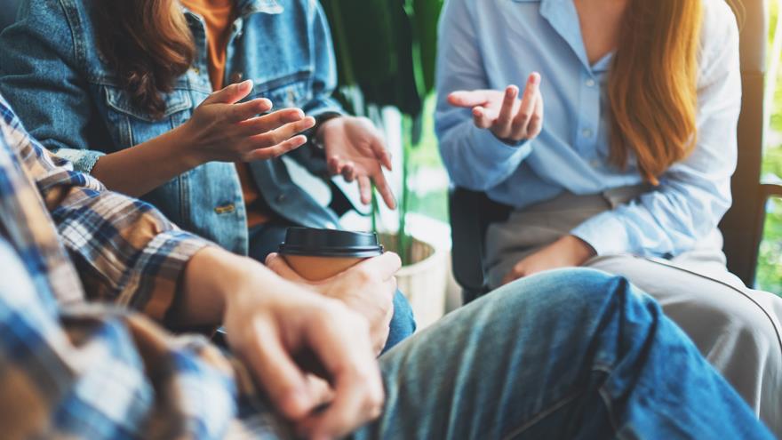 Close up image of three people talking using hand gestures